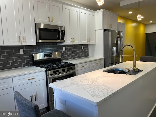 kitchen featuring white cabinetry, sink, light stone countertops, stainless steel appliances, and tasteful backsplash