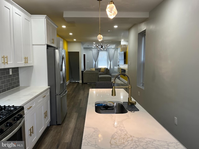 kitchen with white cabinets, stainless steel appliances, and hanging light fixtures