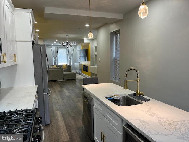 kitchen featuring pendant lighting, sink, white cabinets, and stainless steel appliances