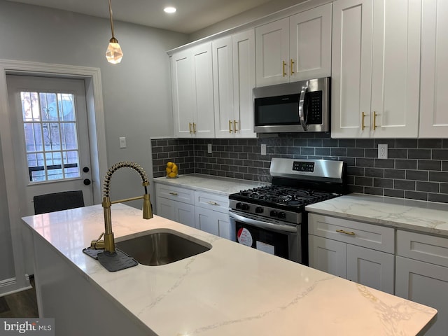 kitchen featuring backsplash, light stone counters, sink, and stainless steel appliances