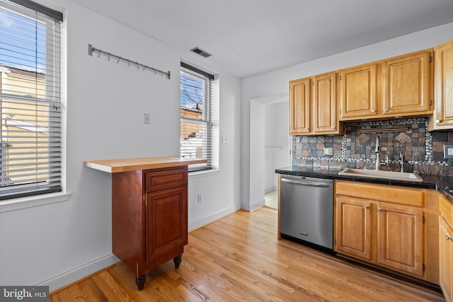 kitchen featuring dishwasher, tasteful backsplash, light hardwood / wood-style flooring, and sink