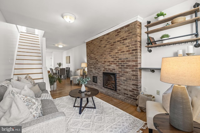 living room featuring light hardwood / wood-style flooring and a brick fireplace