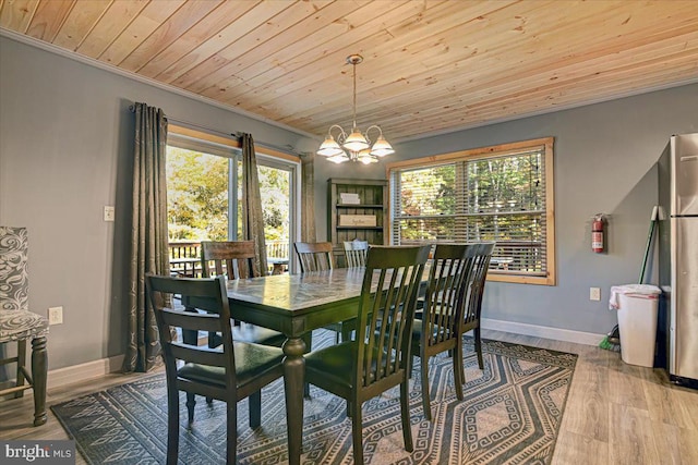 dining space featuring light wood-type flooring, an inviting chandelier, wooden ceiling, and crown molding