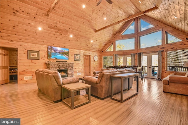 living room featuring beam ceiling, light wood-type flooring, high vaulted ceiling, and a wealth of natural light