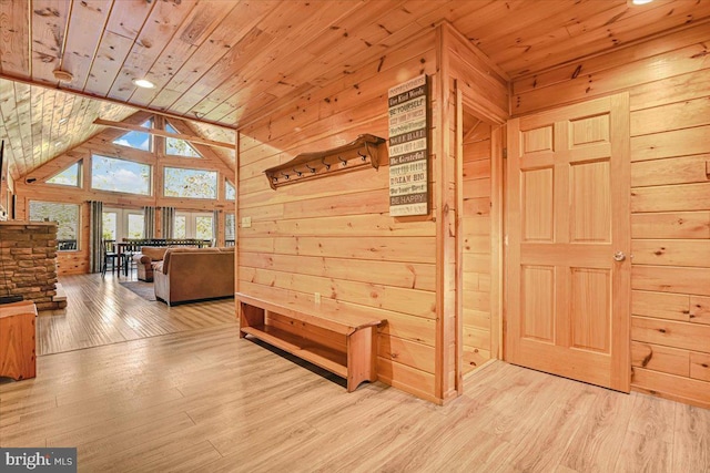 hall with hardwood / wood-style flooring, vaulted ceiling with skylight, wood ceiling, and wooden walls