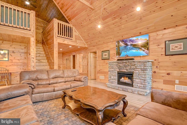 living room with wooden walls, high vaulted ceiling, and wooden ceiling