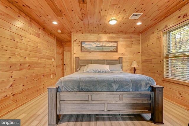 bedroom with light hardwood / wood-style floors, wooden walls, and wood ceiling