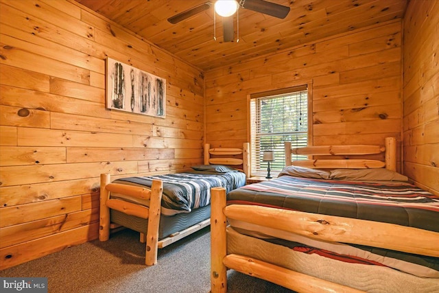 carpeted bedroom with ceiling fan, wooden ceiling, and wooden walls