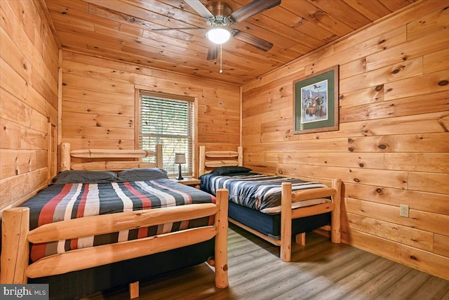 bedroom with wood-type flooring, wood ceiling, ceiling fan, and wood walls