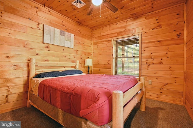 carpeted bedroom with ceiling fan, wooden walls, and wood ceiling