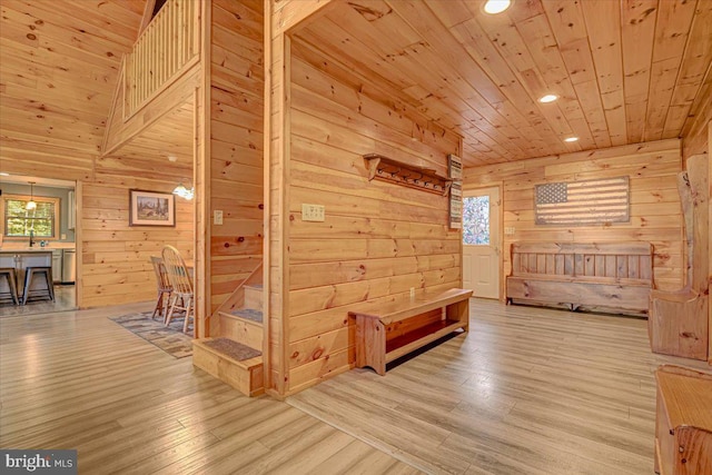 hall featuring wood walls, wooden ceiling, a healthy amount of sunlight, and light wood-type flooring