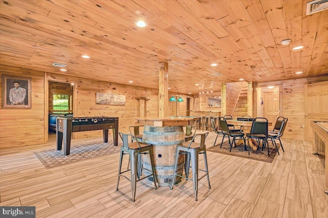 dining area featuring wood ceiling, wooden walls, and light hardwood / wood-style floors