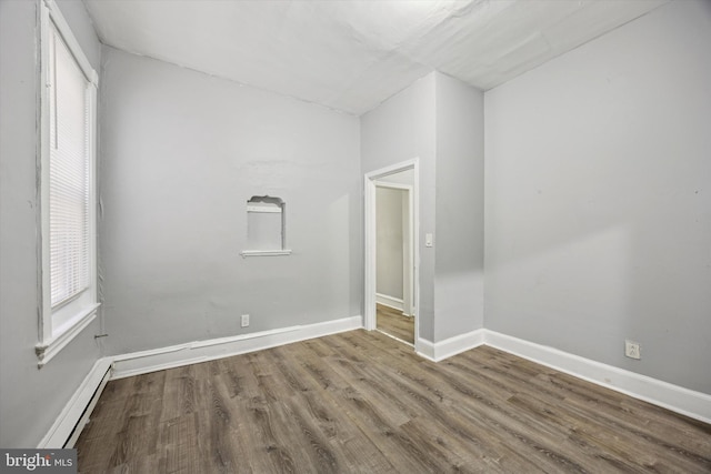 unfurnished room featuring hardwood / wood-style flooring and baseboard heating