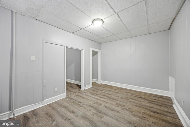 empty room with a paneled ceiling and hardwood / wood-style flooring