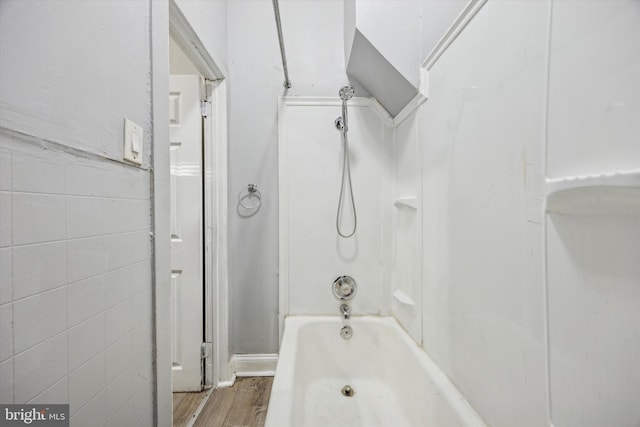 bathroom with hardwood / wood-style floors and shower / washtub combination