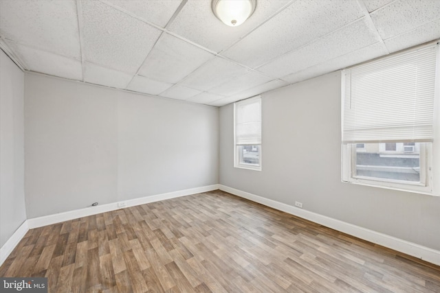 unfurnished room featuring light wood-type flooring and a drop ceiling