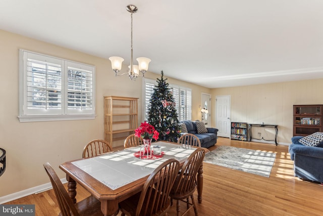 dining area with hardwood / wood-style floors and a notable chandelier