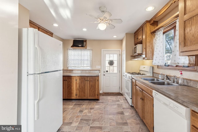 kitchen featuring white appliances, ceiling fan, and sink