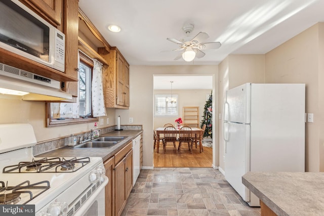 kitchen featuring pendant lighting, a healthy amount of sunlight, white appliances, and sink