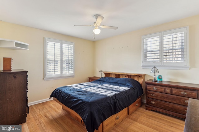 bedroom featuring multiple windows, ceiling fan, and light wood-type flooring