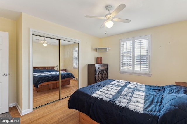 bedroom with hardwood / wood-style flooring, ceiling fan, and a closet