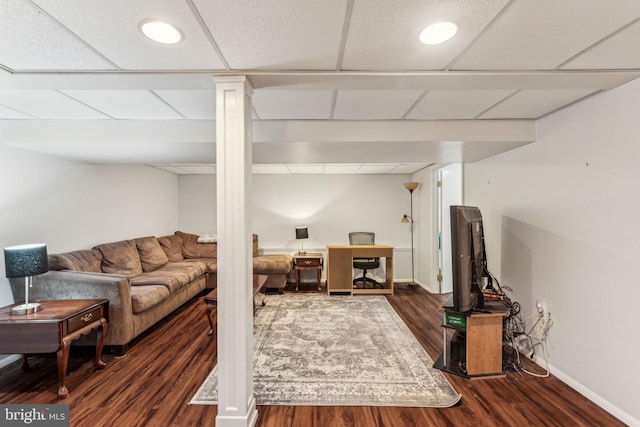 living room with a paneled ceiling and dark hardwood / wood-style floors