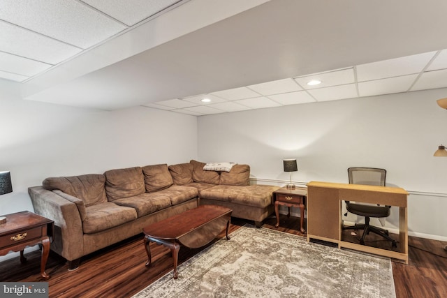 living room featuring a paneled ceiling and dark hardwood / wood-style flooring