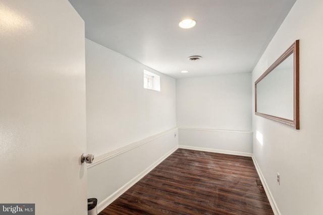 basement with dark hardwood / wood-style flooring