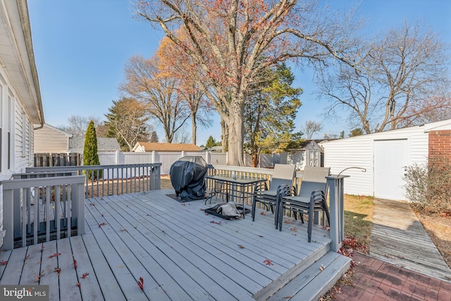 wooden deck featuring a grill and a shed