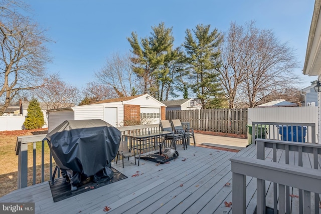 wooden deck with area for grilling, a garage, and an outdoor structure