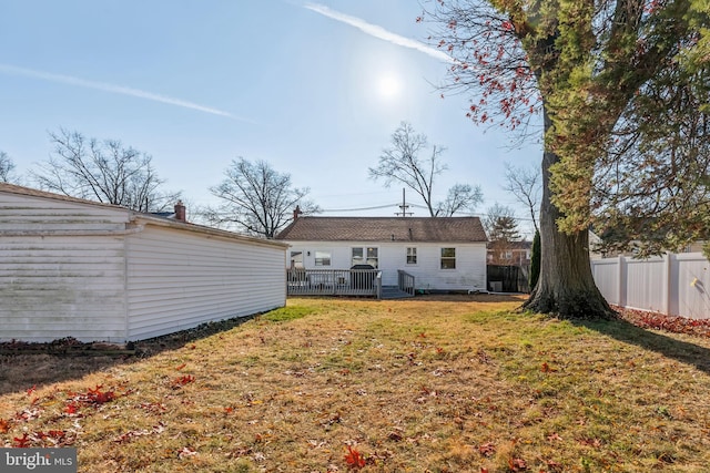 back of house featuring a yard and a wooden deck