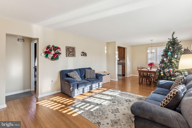 living room with hardwood / wood-style flooring and a notable chandelier