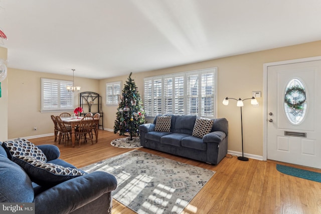 living room featuring a chandelier, light hardwood / wood-style flooring, and a healthy amount of sunlight