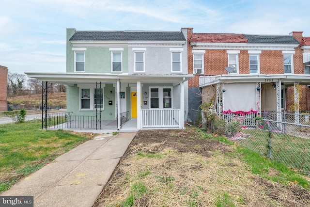 view of property with covered porch and a front yard