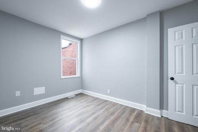 unfurnished room with dark hardwood / wood-style flooring