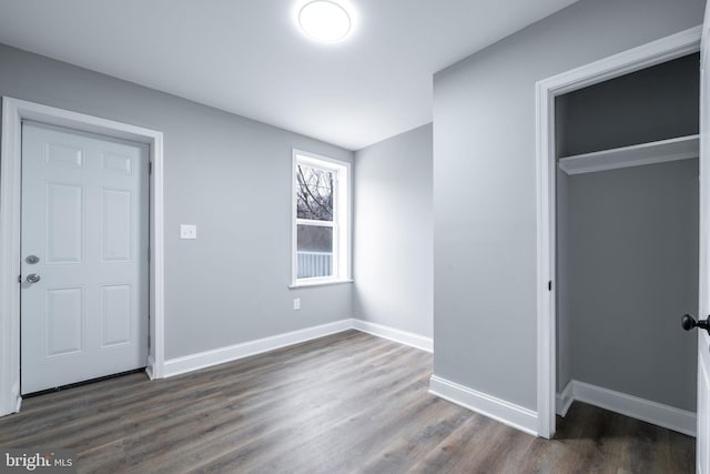 unfurnished bedroom featuring dark hardwood / wood-style floors and a closet