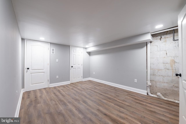 basement with dark hardwood / wood-style flooring