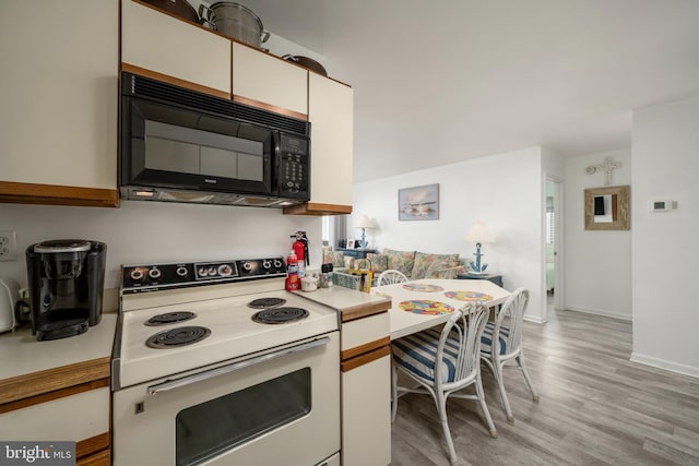 kitchen featuring white cabinetry, light wood-type flooring, and electric stove