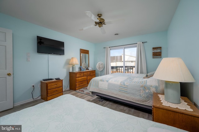 bedroom with access to exterior, ceiling fan, and wood-type flooring