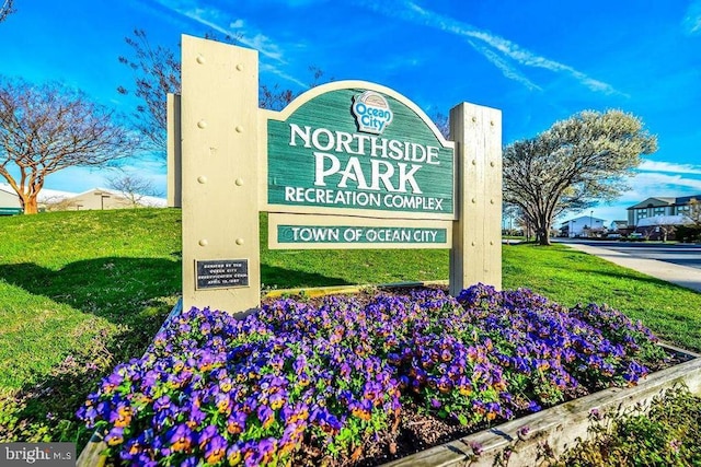 community / neighborhood sign featuring a yard