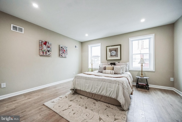 bedroom featuring multiple windows and light hardwood / wood-style floors