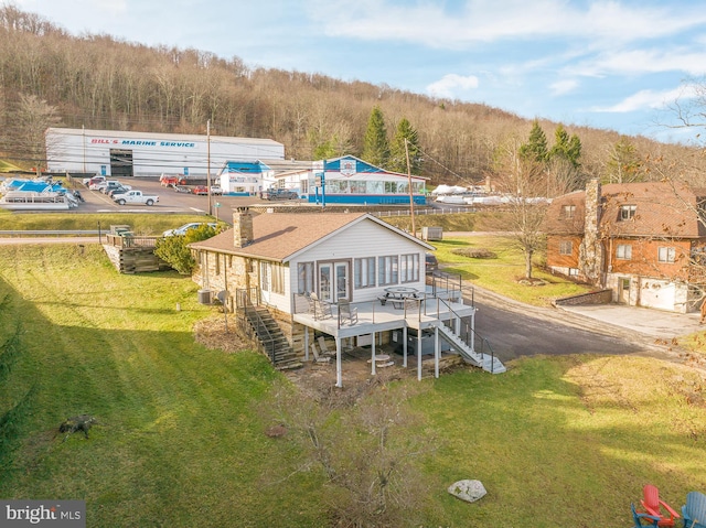 rear view of property featuring a lawn and a deck