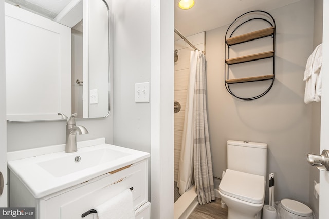 bathroom featuring a shower with curtain, hardwood / wood-style flooring, vanity, and toilet