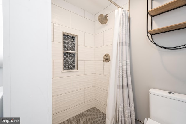 bathroom featuring a shower with curtain and toilet