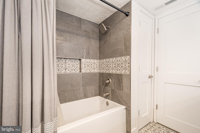 bathroom featuring a textured ceiling and shower / bathtub combination with curtain