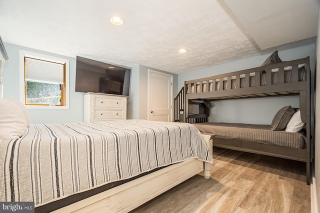 bedroom featuring light hardwood / wood-style floors and a textured ceiling