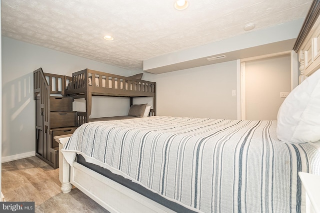 bedroom with light hardwood / wood-style flooring and a textured ceiling