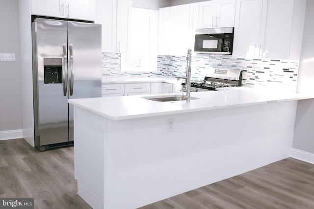 kitchen with white cabinets, stainless steel fridge with ice dispenser, and kitchen peninsula