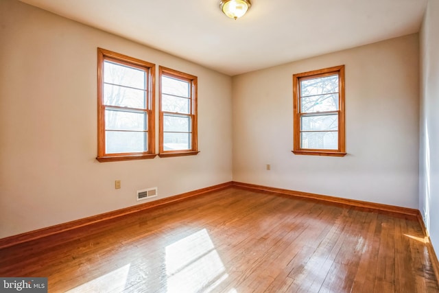 unfurnished room with hardwood / wood-style floors