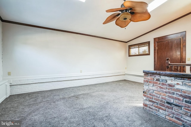 interior space featuring vaulted ceiling, ornamental molding, ceiling fan, and carpet flooring